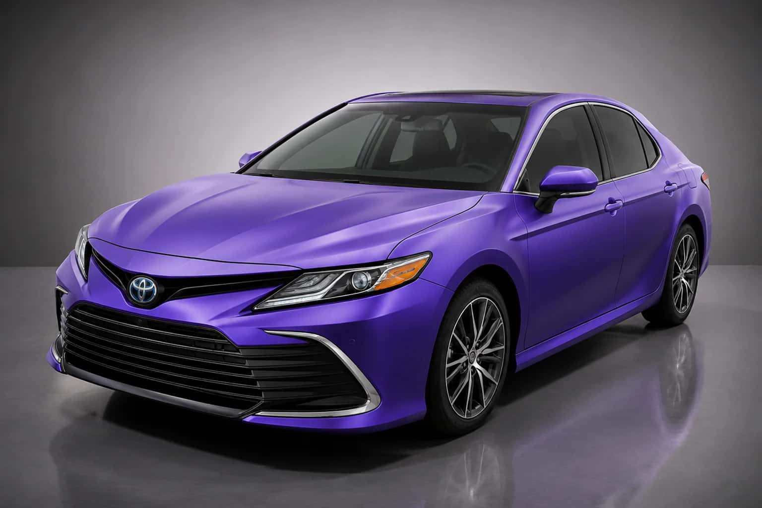 Purple-wrapped Toyota Camry in a dark reflection studio